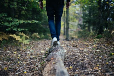 Person walking on a log in the woods