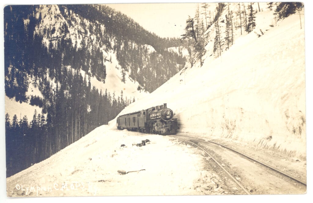 Historic photo of train going over a snowy Snoqualmie Pass