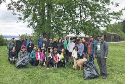 Group of volunteers posing in front of a tree after trash cleanup event